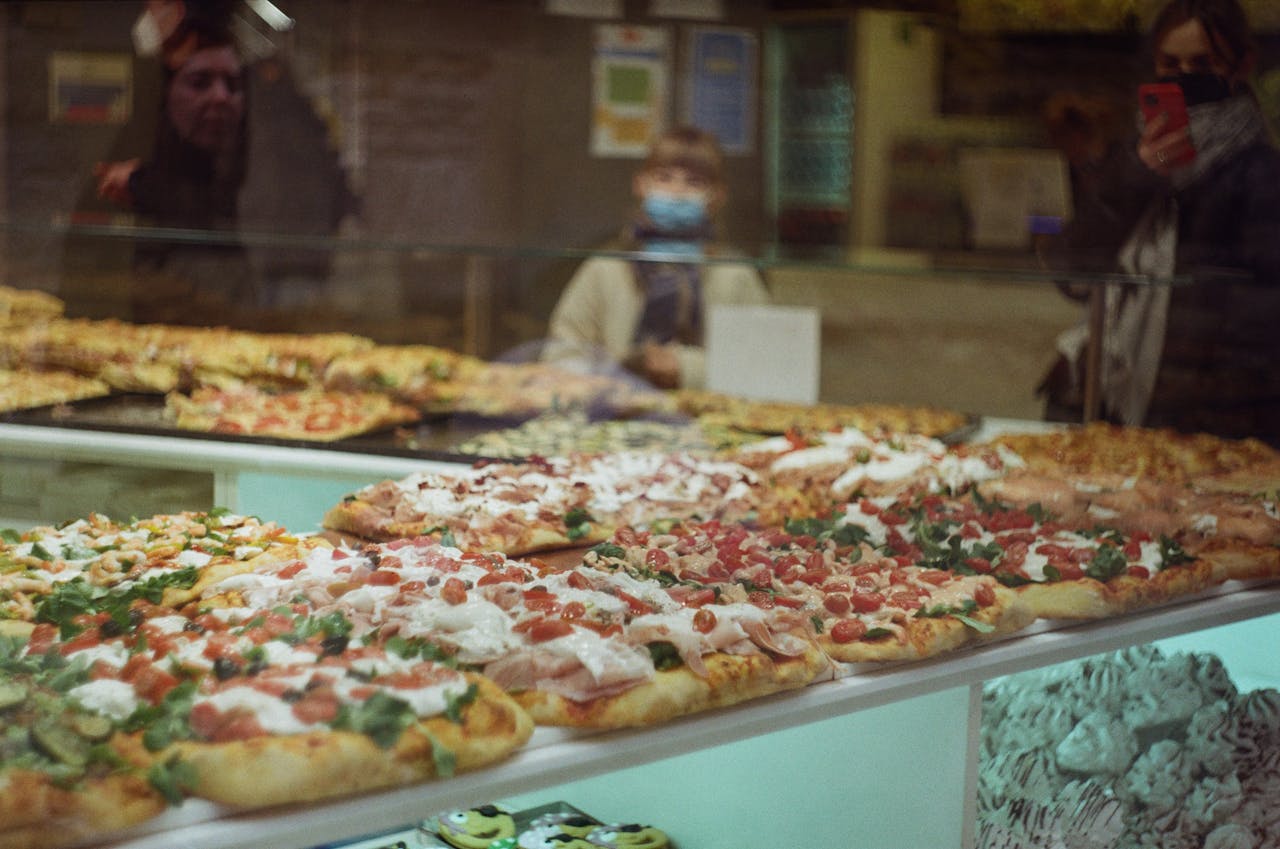 Tempting display of assorted pizzas in a Bergamo bakery showcasing Italian culinary delights.