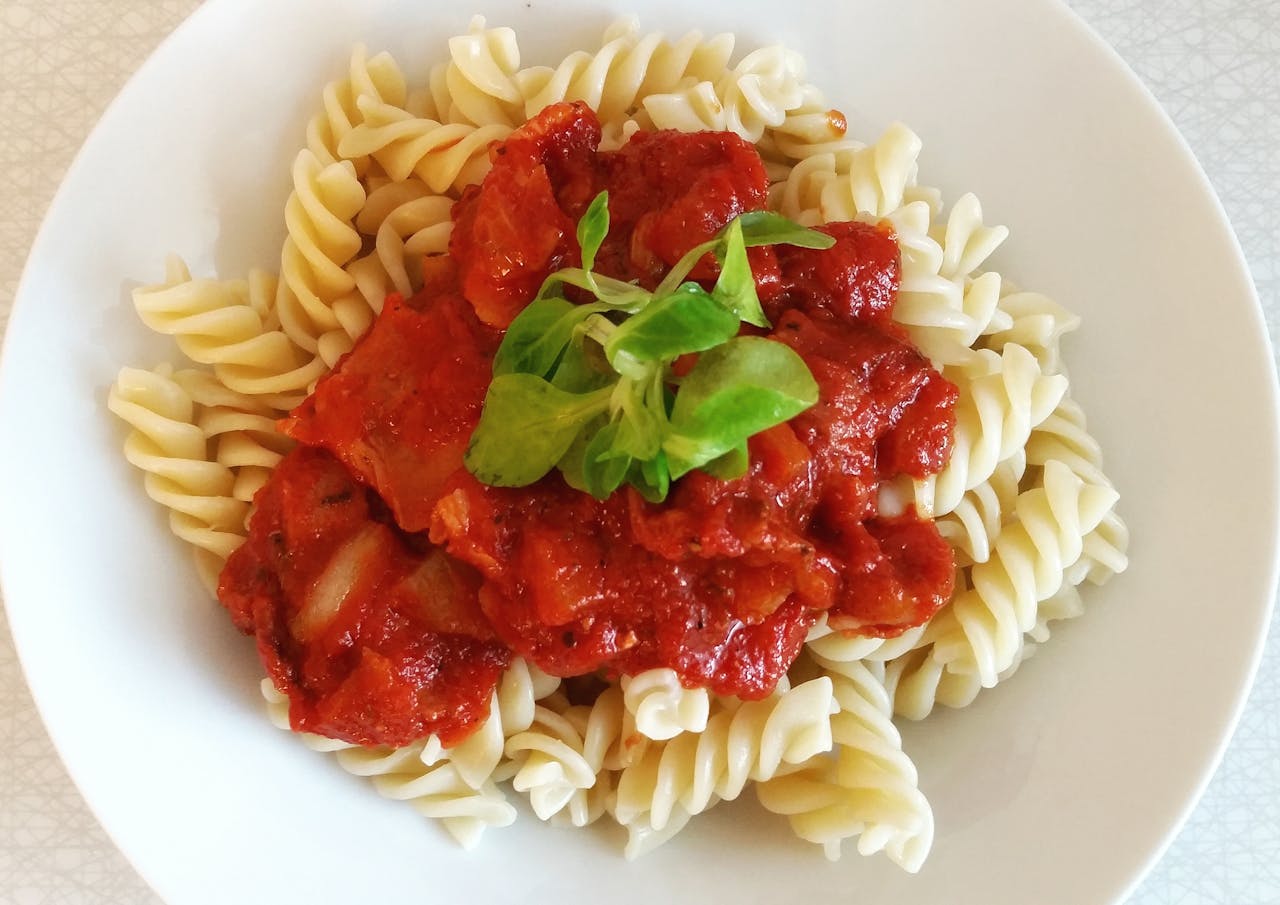 Spirelli pasta topped with rich tomato sauce and fresh greens for a perfect meal.